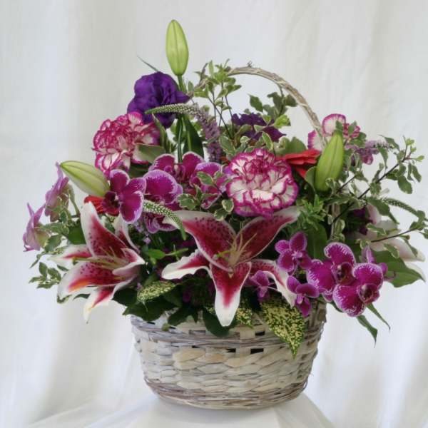 Basket arrangement with pink and purple flowers and lilies