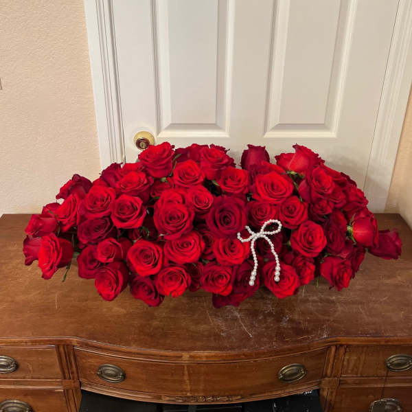 Large arrangement of red roses with a pearl bow accent