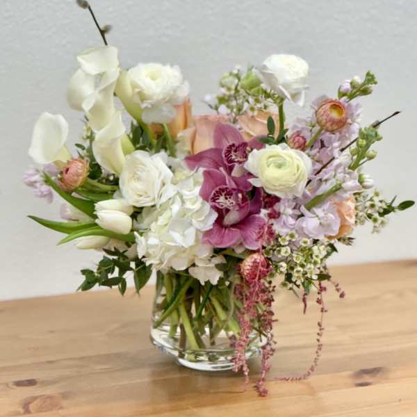 Mixed bouquet in a clear glass vase with white, pink, and peach flowers