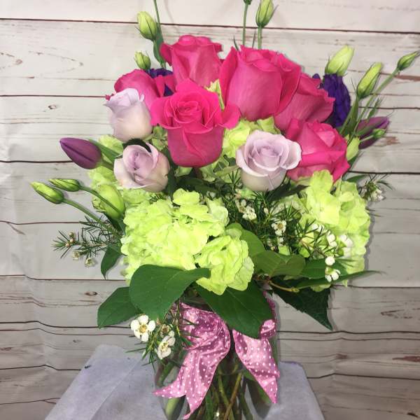 Pink and lavender roses with lime hydrangeas in a glass vase