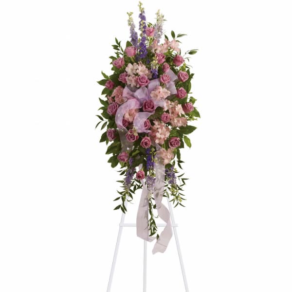 Tall pink and purple floral standing spray on a white easel