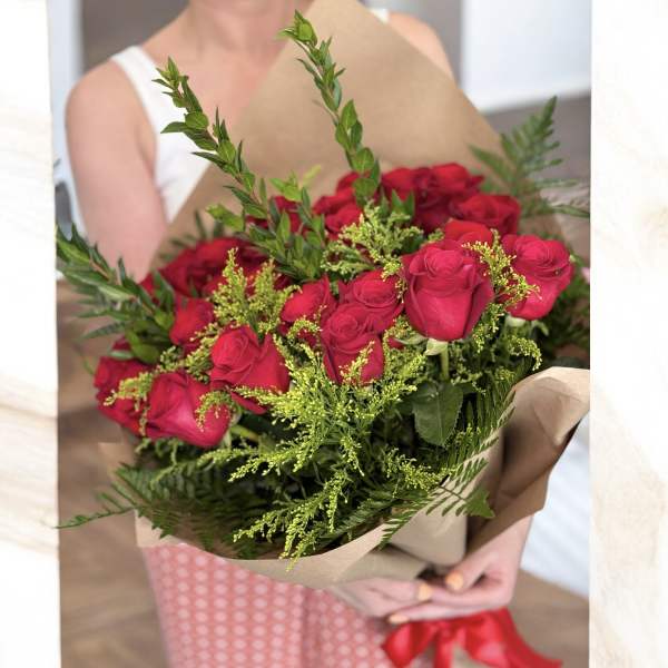 Bouquet of red roses wrapped in brown paper