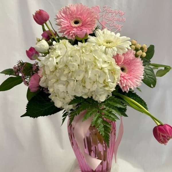 Pink and white bouquet in a pink vase with a Mother's Day sign