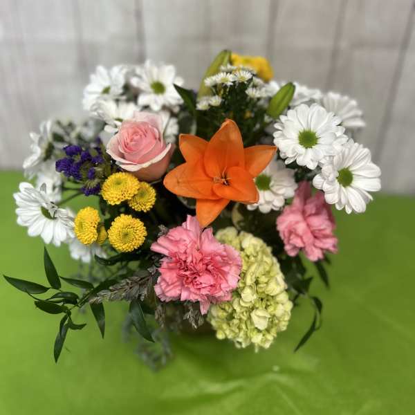 Mixed bouquet with a pink rose, orange lily, and white daisies