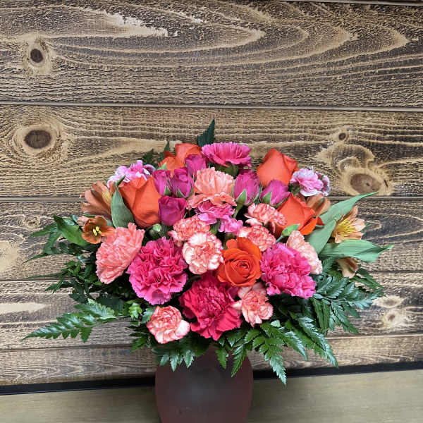 Pink and orange mixed bouquet in a brown vase