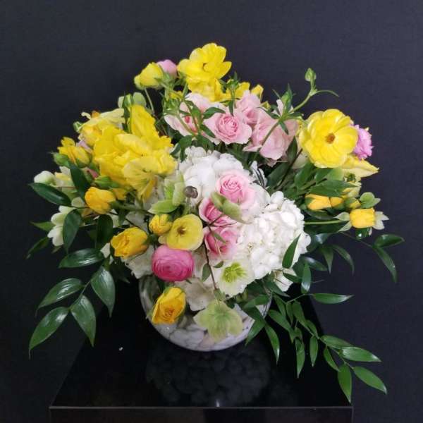 Bouquet of yellow and pink flowers in a white vase
