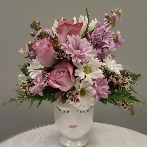 Pink and white mixed bouquet in a white face vase