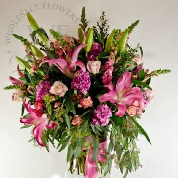 Pink lilies and roses in a clear glass vase