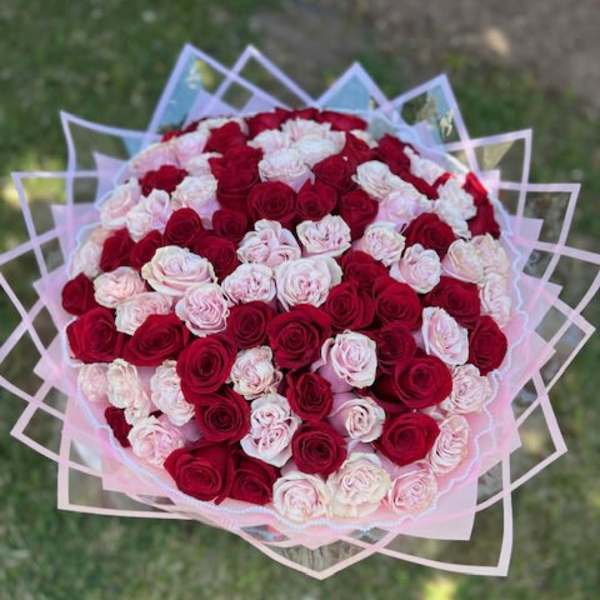 Large bouquet of red and pale pink roses wrapped in pink paper