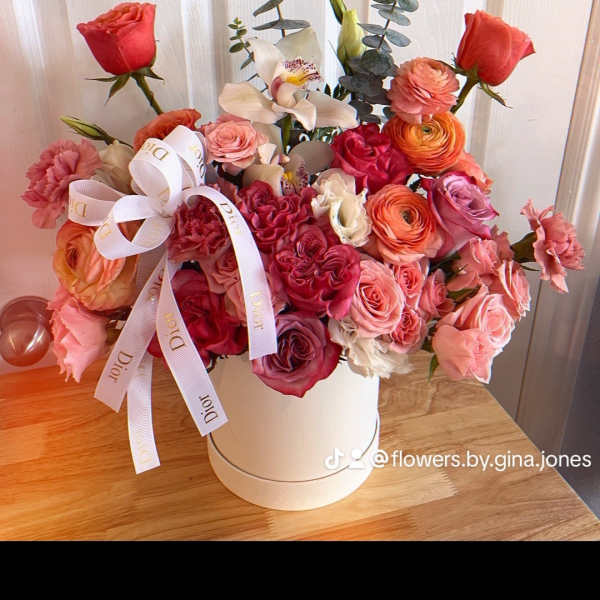 Pink and coral rose bouquet in a white hat box with a ribbon bow