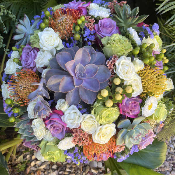 Round bouquet with roses, succulents, and orange pincushion blooms