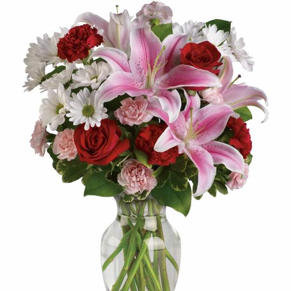 Bouquet of pink lilies, red roses, white daisies, and carnations in a glass vase