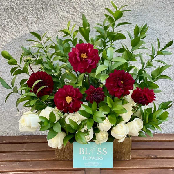 Red dahlias and white roses in a rectangular container