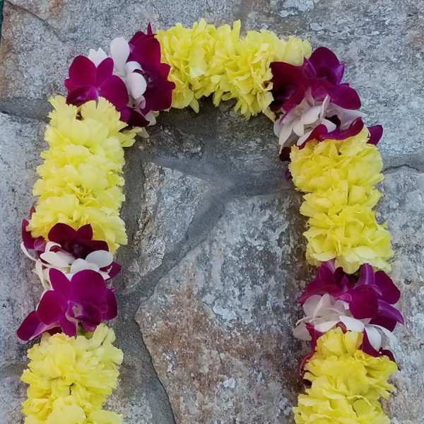 Yellow and purple floral lei arranged in a loop