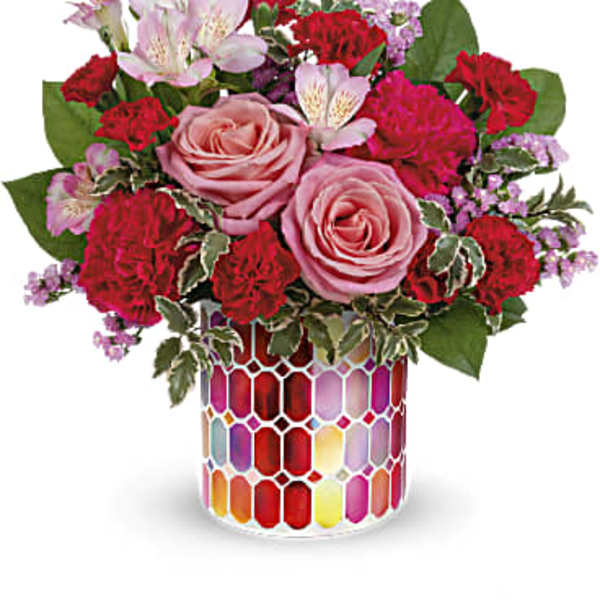 Pink roses and red carnations in a colorful mosaic vase