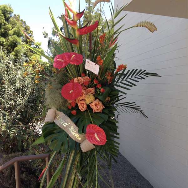 Tall tropical standing spray with pink anthuriums and orange roses