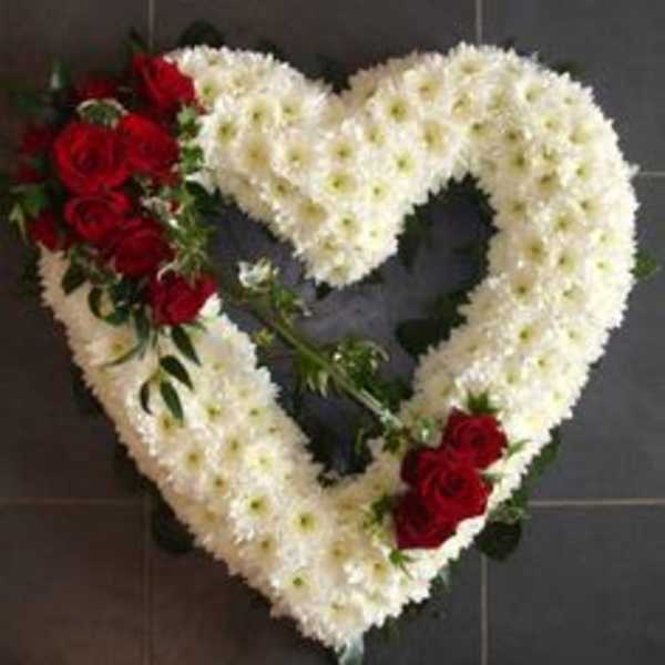 Heart-shaped floral wreath with white flowers and red roses