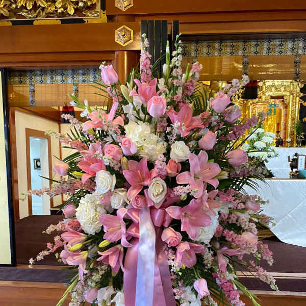 Large pink and white floral standing arrangement with ribbon