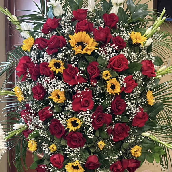 Large standing spray of red roses, yellow sunflowers, and white gladiolus