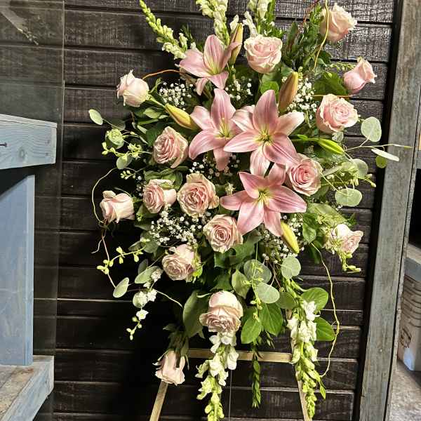 Pink lilies and roses arranged on a standing easel