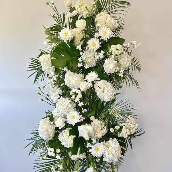 Tall white floral standing spray with roses and chrysanthemums