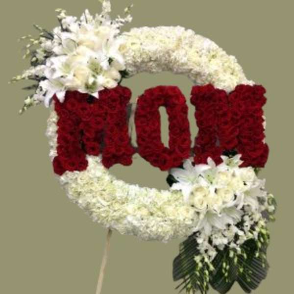 Floral standing tribute shaped like the word LOVE in red and white flowers