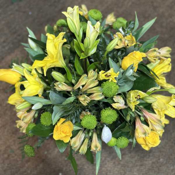 Yellow lilies and roses with green button mums in a bouquet