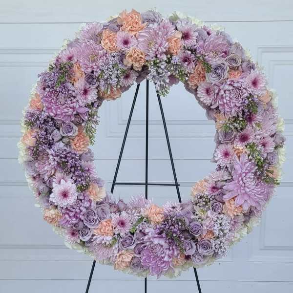 Large pastel floral wreath on a black stand