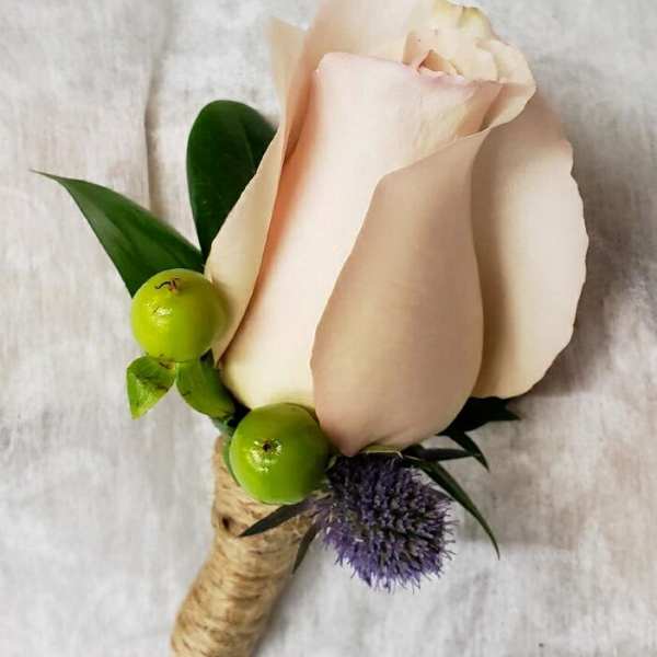 Single pale pink rose boutonniere with green berries and purple accent flower