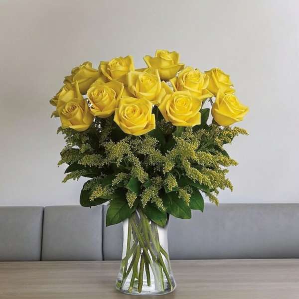 Yellow roses arranged in a clear glass vase