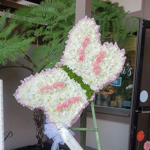 Heart-shaped standing floral tribute with white and pink flowers on an easel