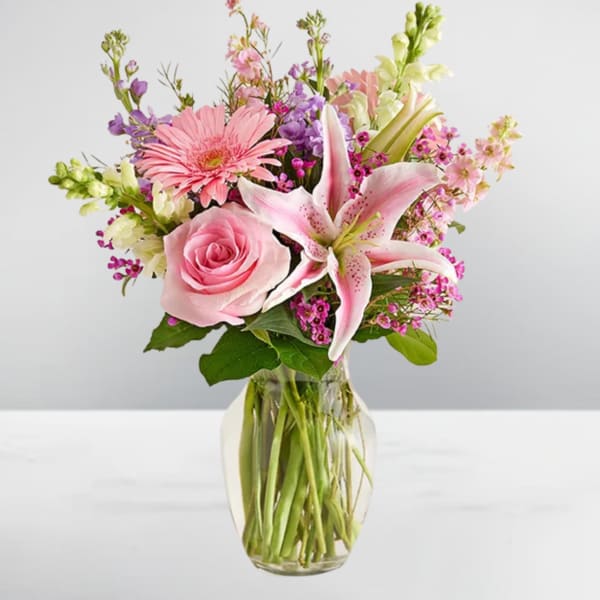 Pink rose and lily bouquet in a clear glass vase