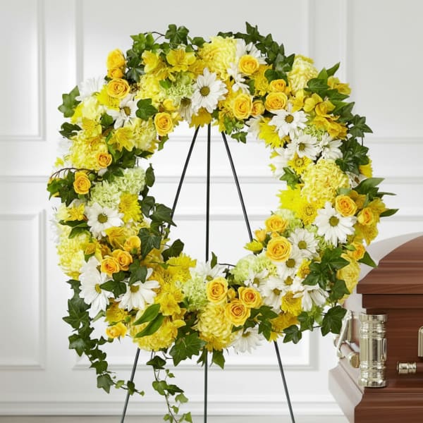 Yellow and white floral wreath on a stand