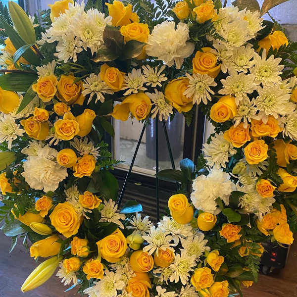 Heart-shaped floral wreath with yellow roses and white chrysanthemums