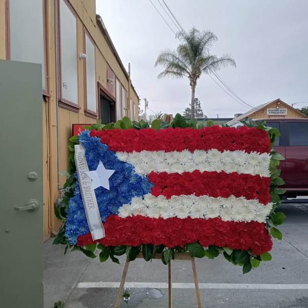 Floral tribute arranged as a Puerto Rican flag on an easel