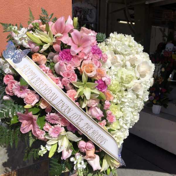 Large pink and white funeral heart wreath with a birthday ribbon