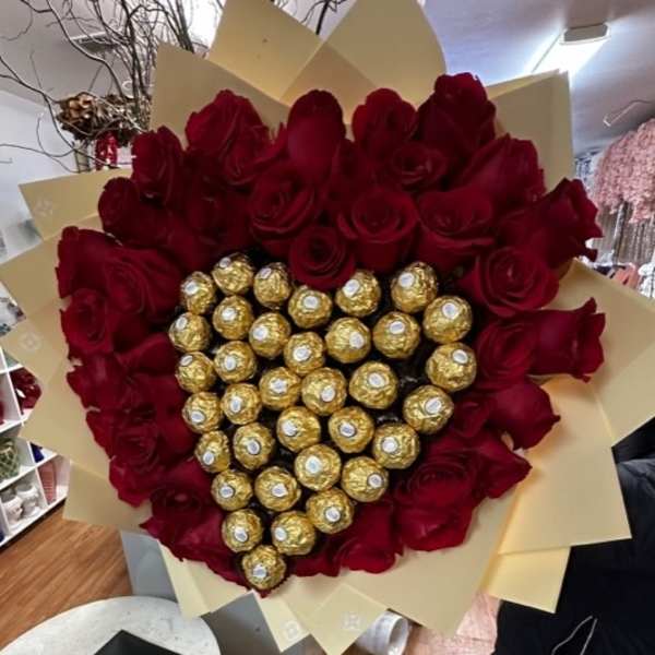 Heart-shaped bouquet of red roses with gold-wrapped chocolates in the center