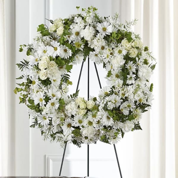 White floral wreath on a black easel