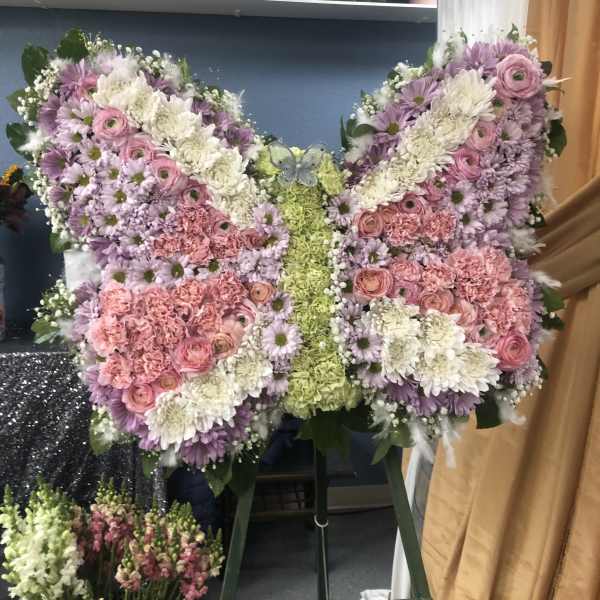 Butterfly-shaped floral arrangement in pink, lavender, white, and green