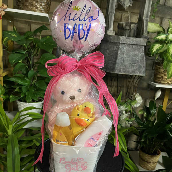 Baby gift basket with a teddy bear, rubber duck, and pink balloon