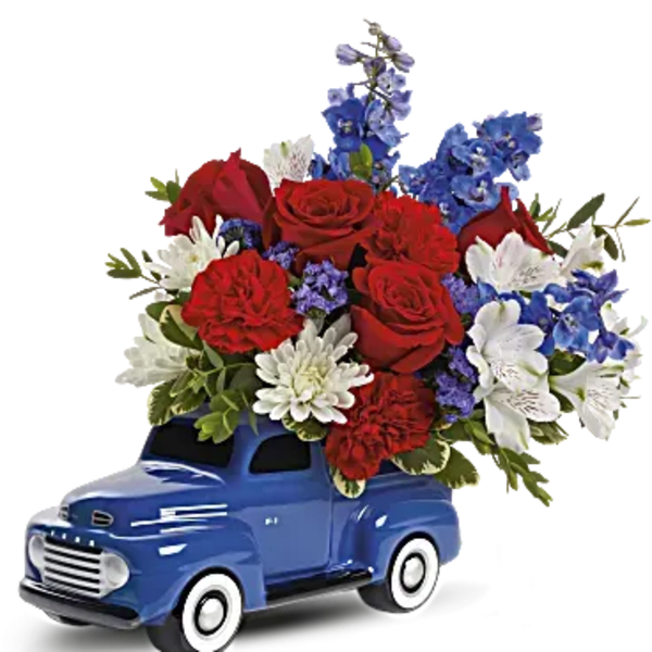 Blue toy truck filled with red, white, and blue flowers