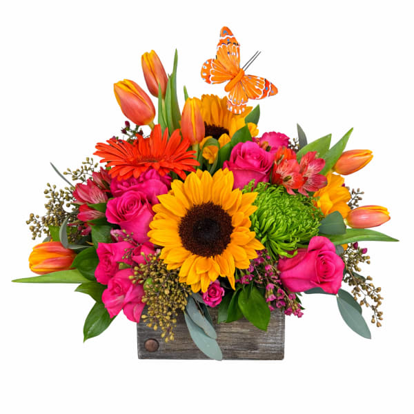 Bright mixed bouquet with sunflowers, pink roses, and tulips in a wooden box