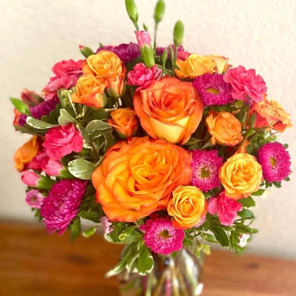 Bouquet of orange and pink flowers in a glass vase