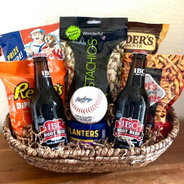 Basket of snacks with two root beer bottles and a baseball