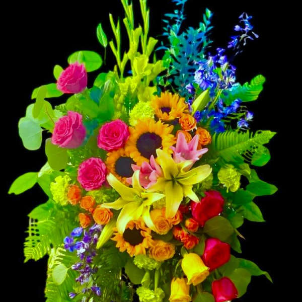 Colorful standing floral arrangement on an easel with sunflowers, roses, and lilies