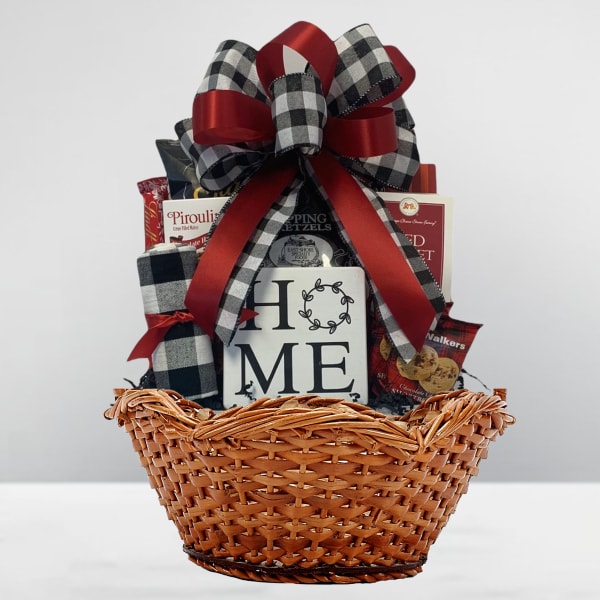 Gift basket with snacks and a HOME sign, topped with a red and plaid bow