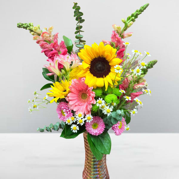 Mixed bouquet with sunflowers, pink gerberas, and small white daisies in a vase