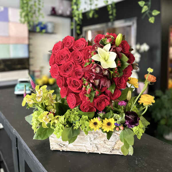Red rose arrangement in a rustic rectangular box with mixed accent flowers