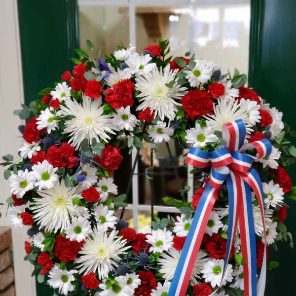 Red, white, and blue floral wreath with a ribbon bow