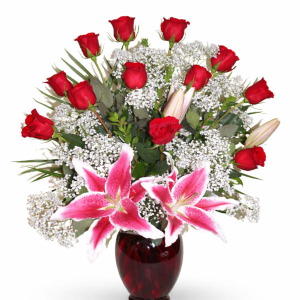Red roses and pink lilies arranged in a dark red vase